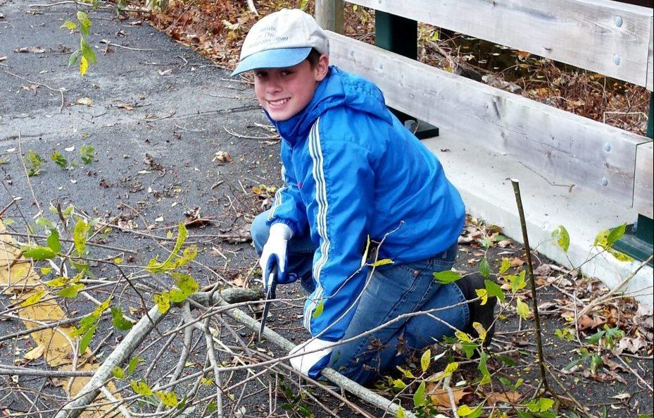 A volunteer helps the Blackstone River Watershed Council/Friends of the Blackstone remove brush along the canal